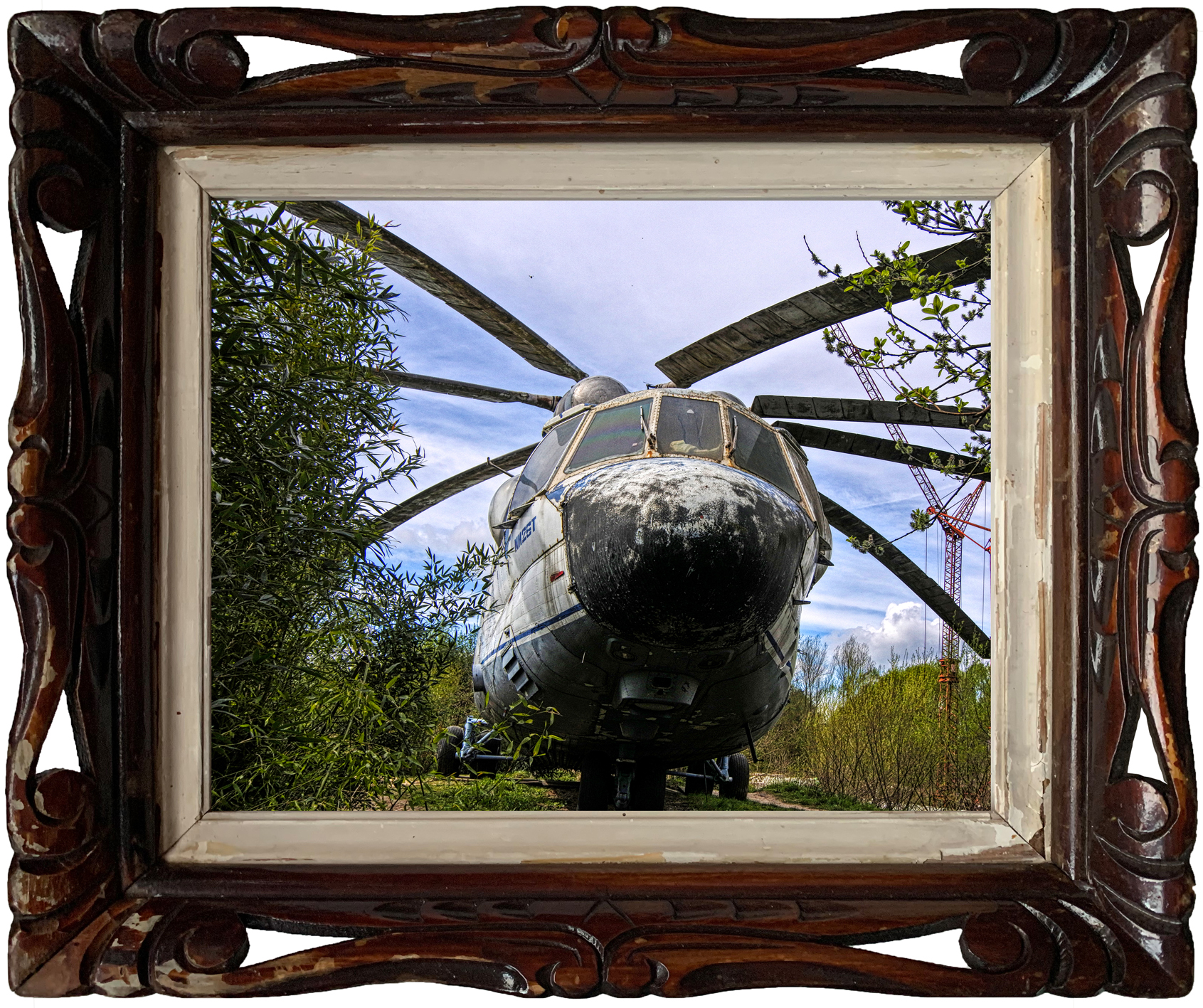 Enorme, verlaten Mil Mi-26T helikopter in een industriële hal, met zichtbaar verval en kunstinstallaties.